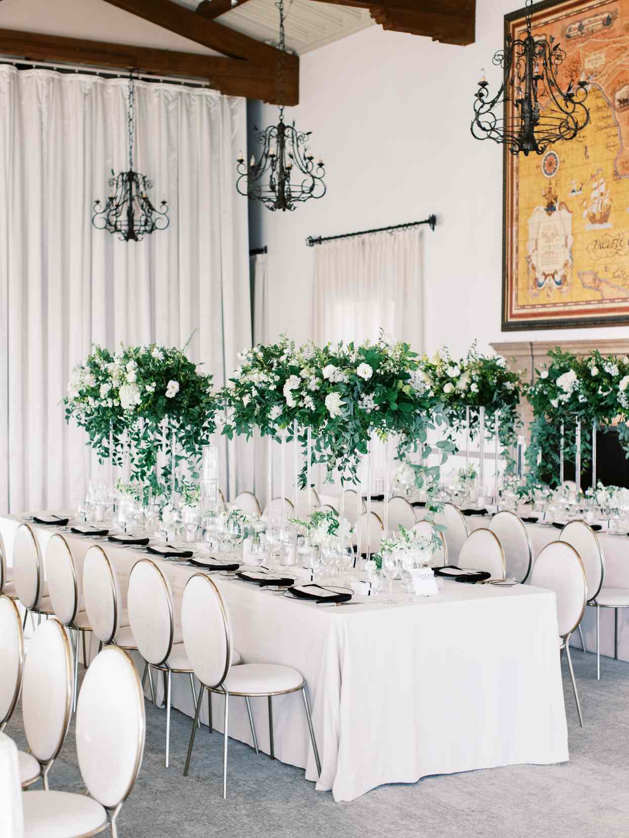 dinner reception seating with long tables with white chairs and tablecloths