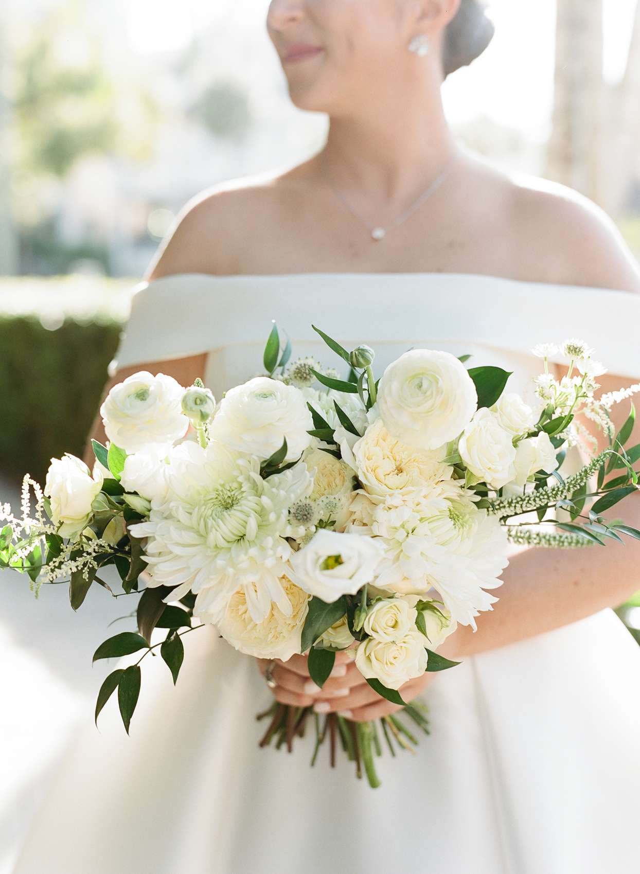 bride holding all white floral bouquet