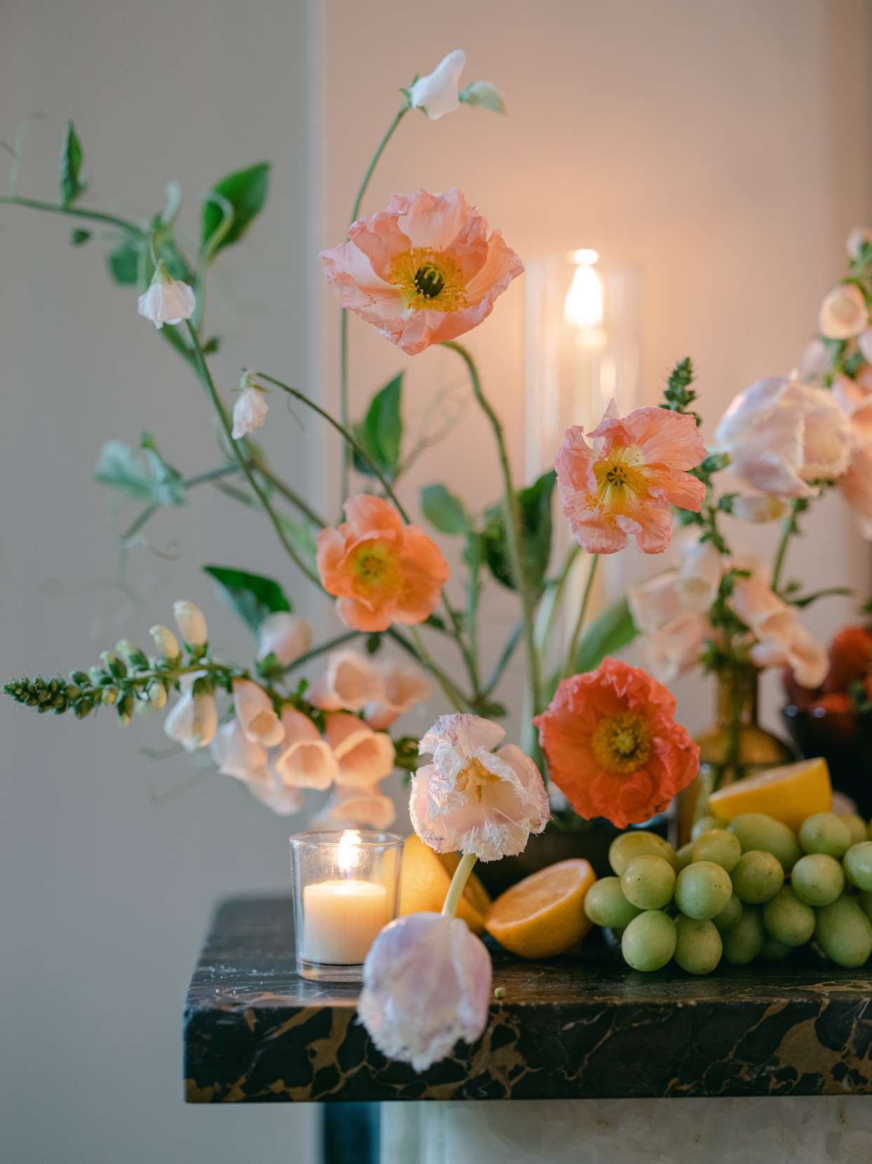 wedding reception mantle with flowers, candles, and citrus fruits