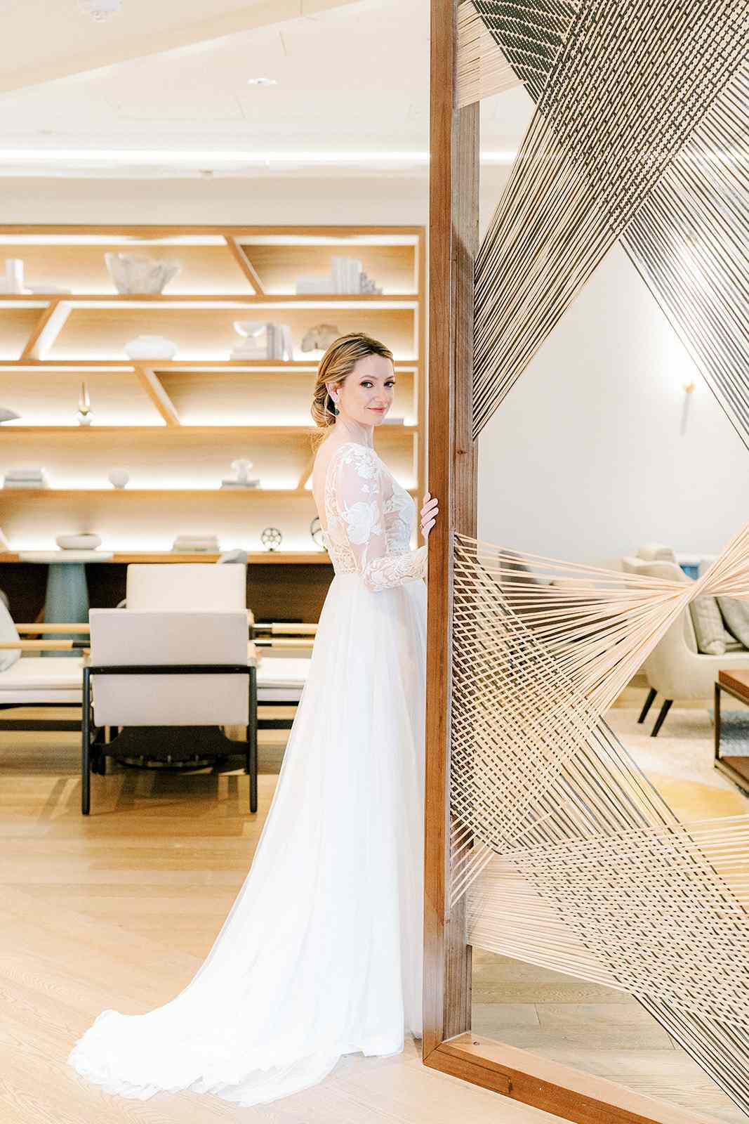 bride in white dress standing next to woven doorway