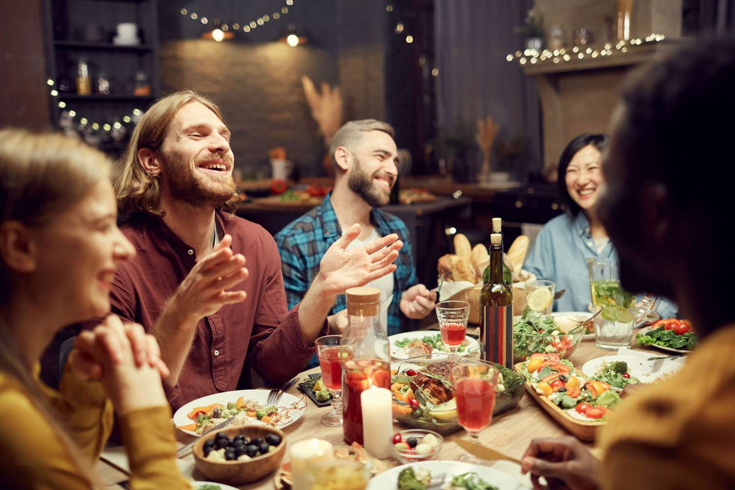Dinner party scene of people laughing while eating