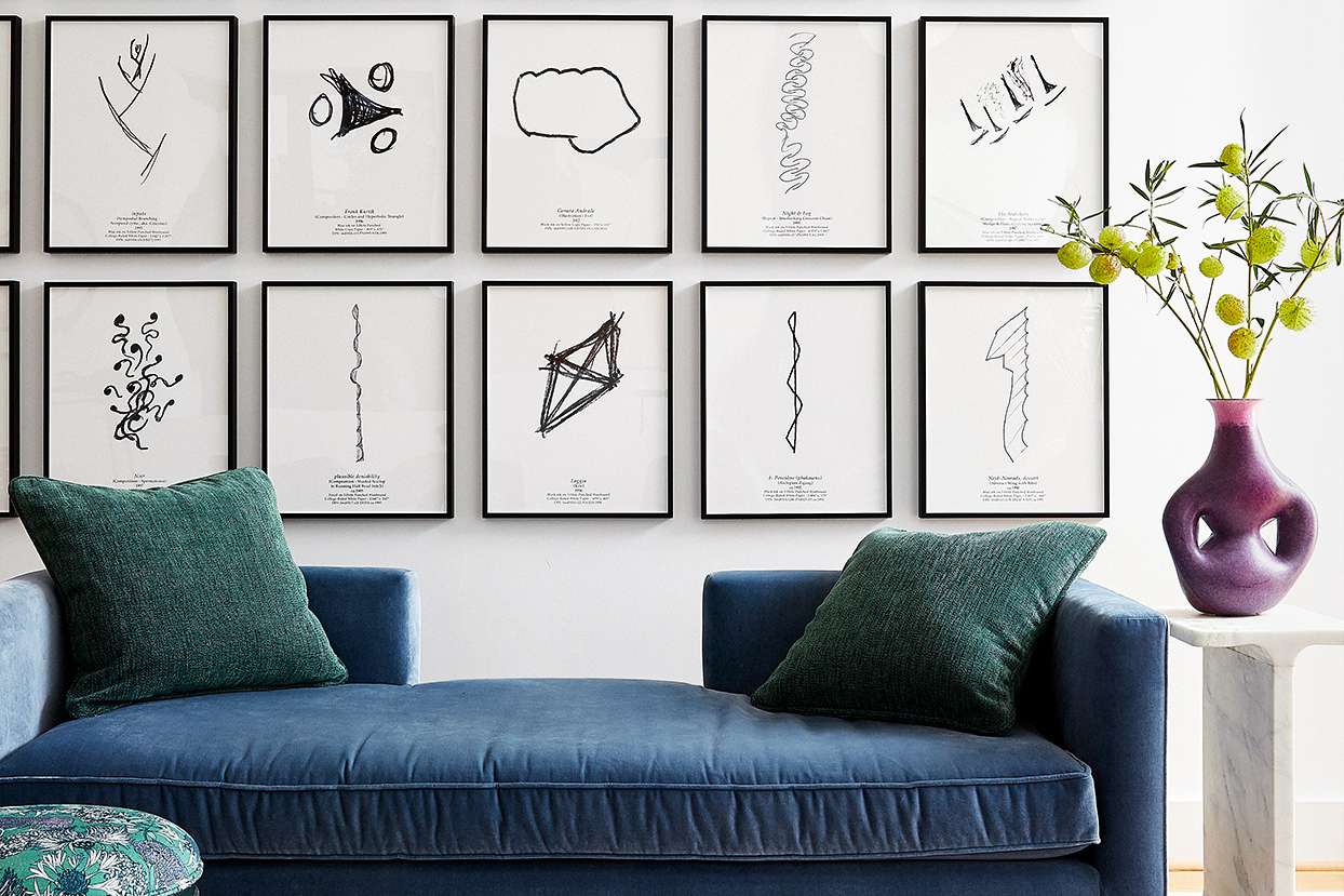 modern art sketches above blue couch in living room
