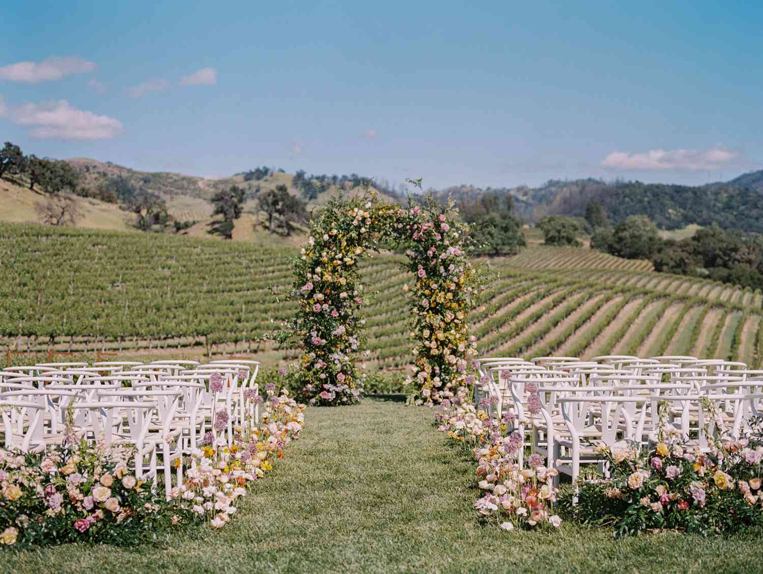 outdoor wedding ceremony floral arch vineyard
