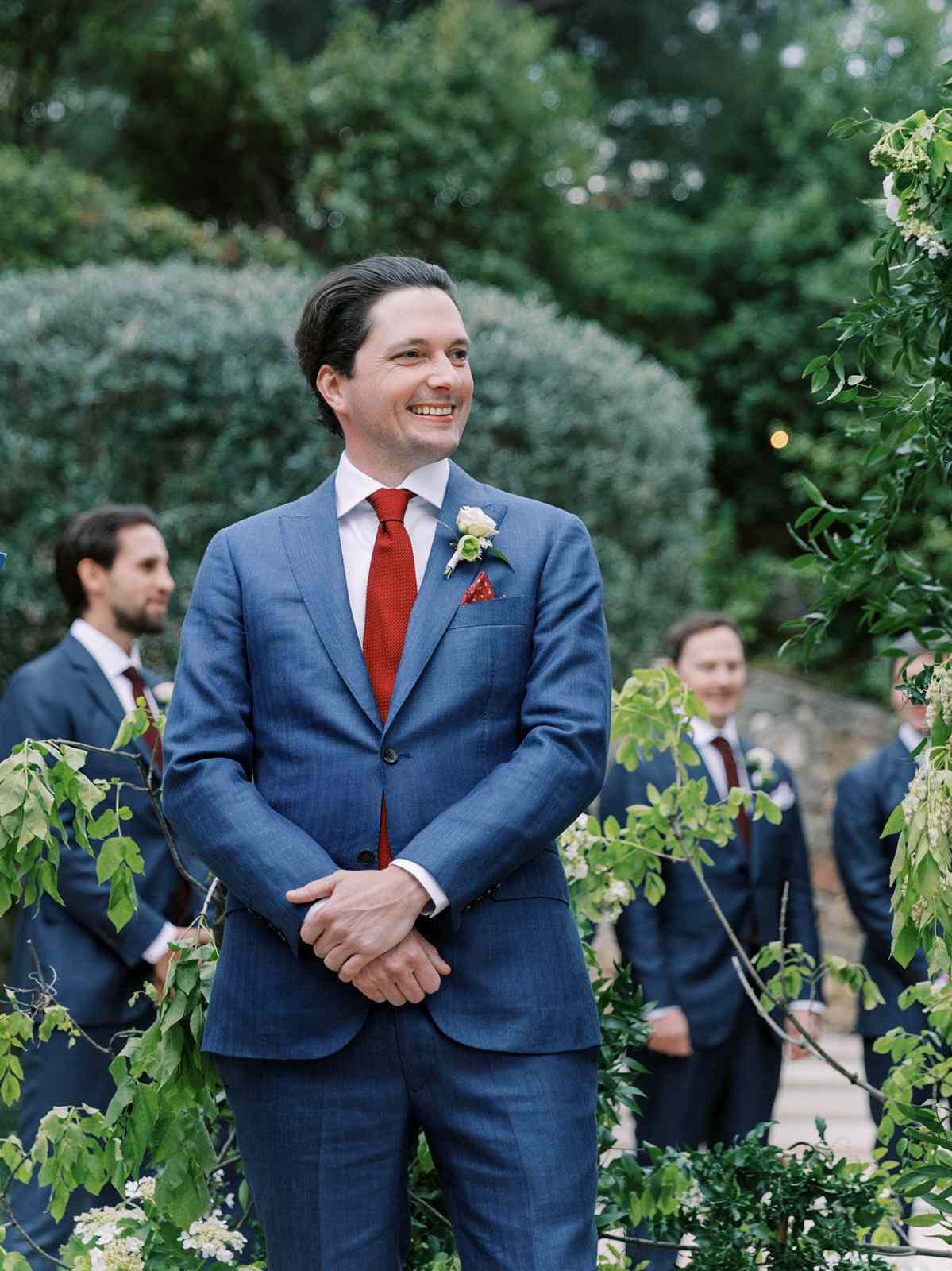 groom in blue suit with red tie