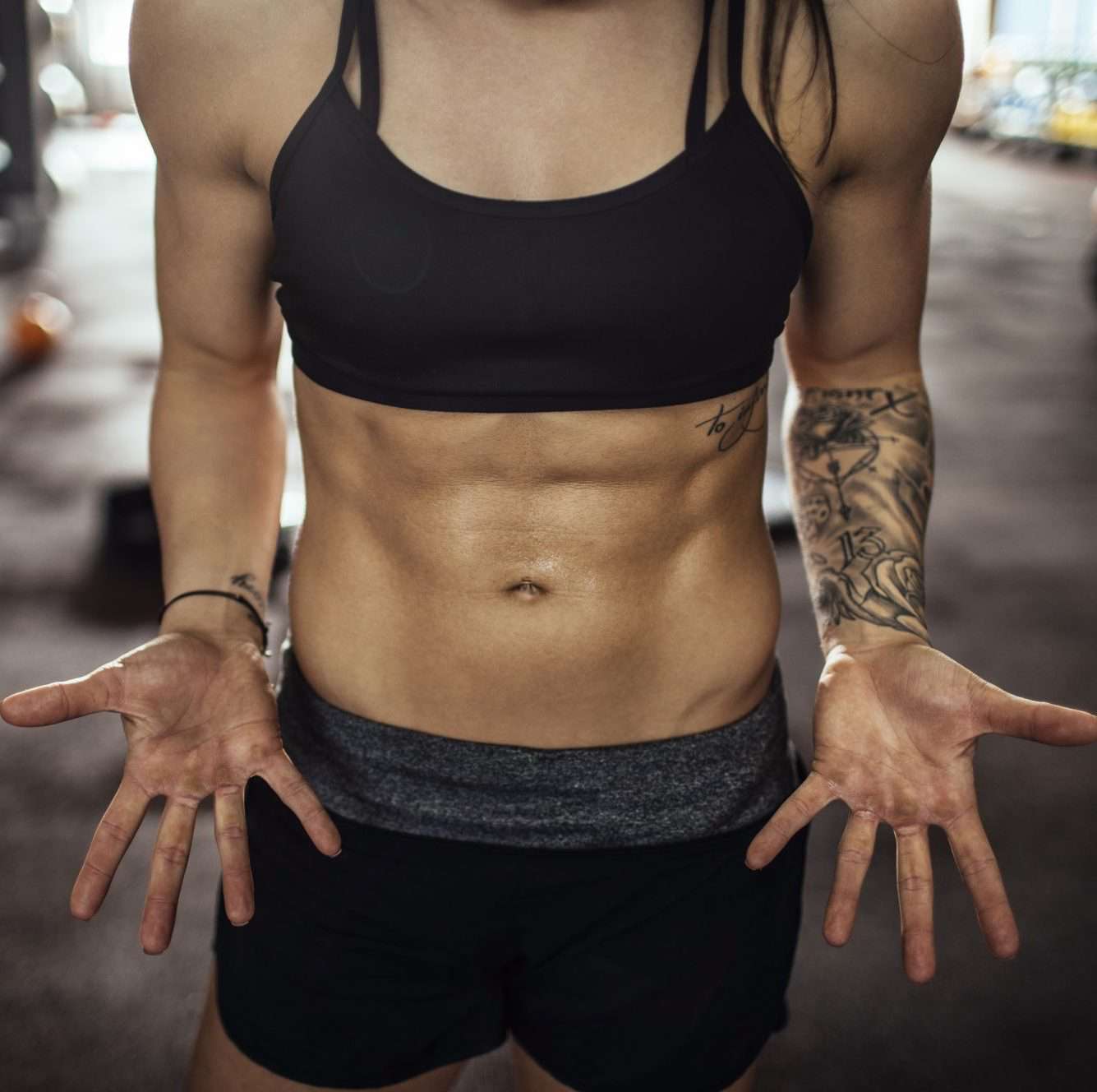 strong woman showing off abs muscles at crossfit gym
