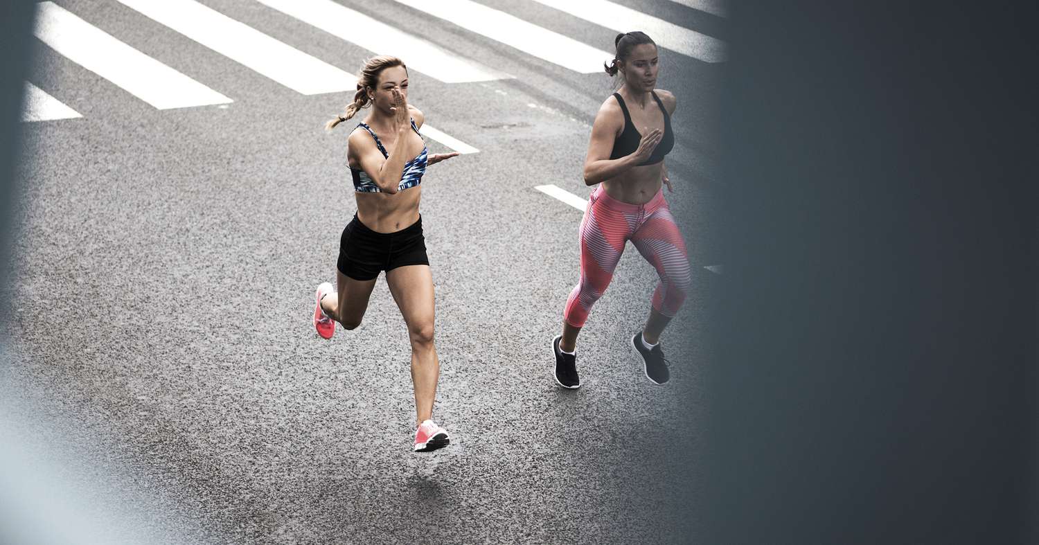 Two young women running on the street