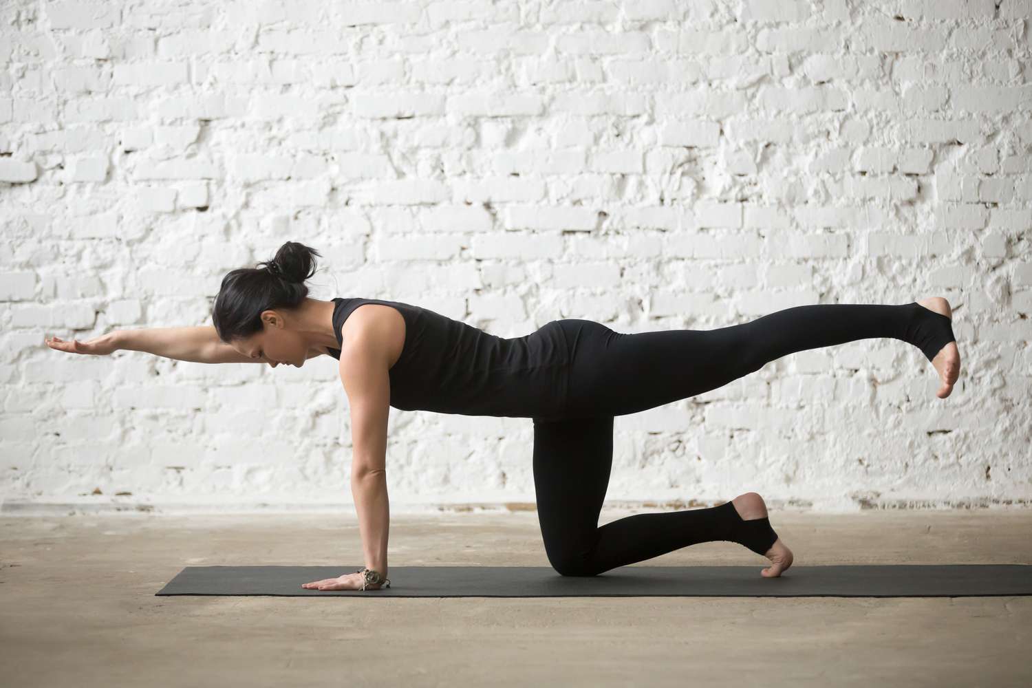 woman doing bird-dog exercise for abs and back strength