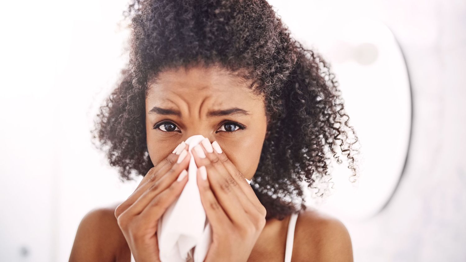 woman blowing nose home remedies for sinus infection