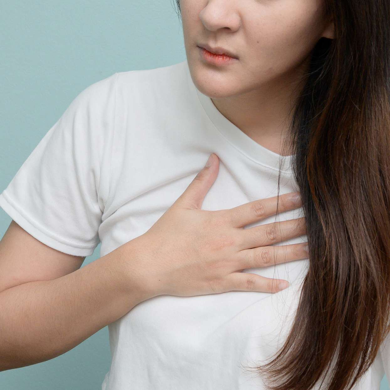 woman holding her chest indicating pain or chest tightness