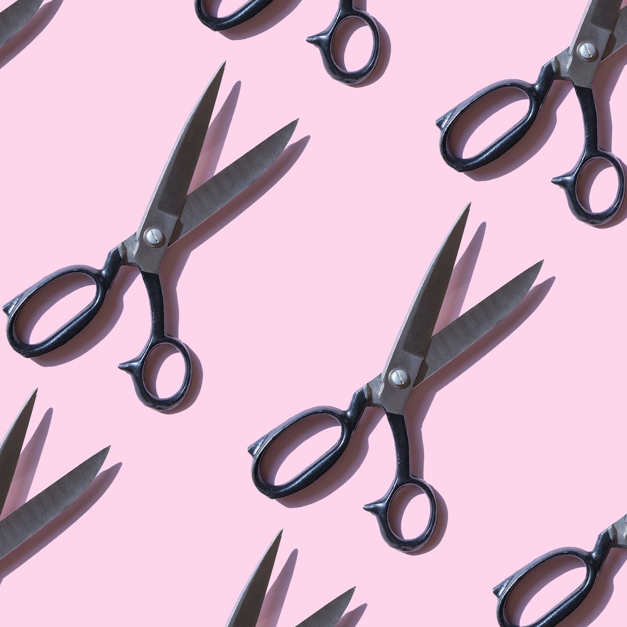 Repeated vintage scissors on pink background