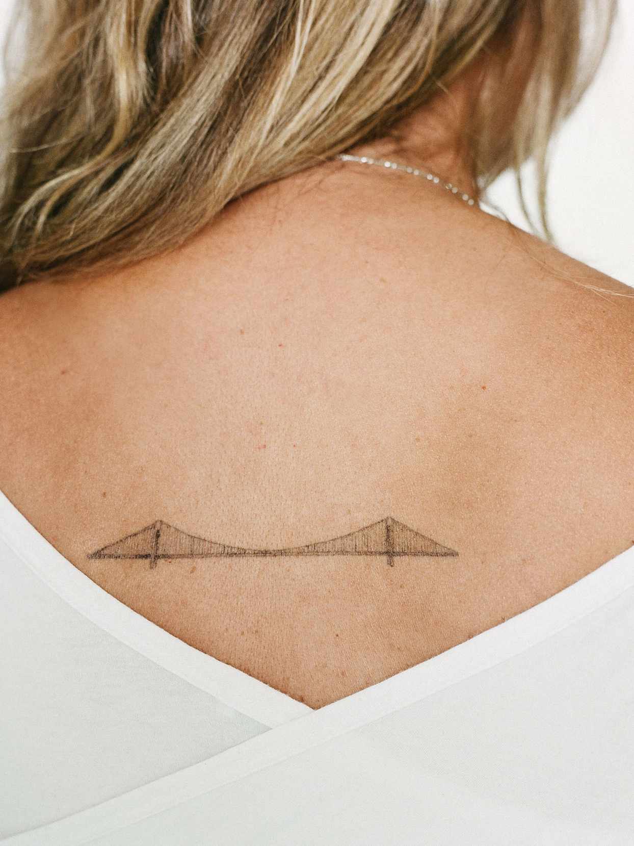 woman with back tattoo of bridge