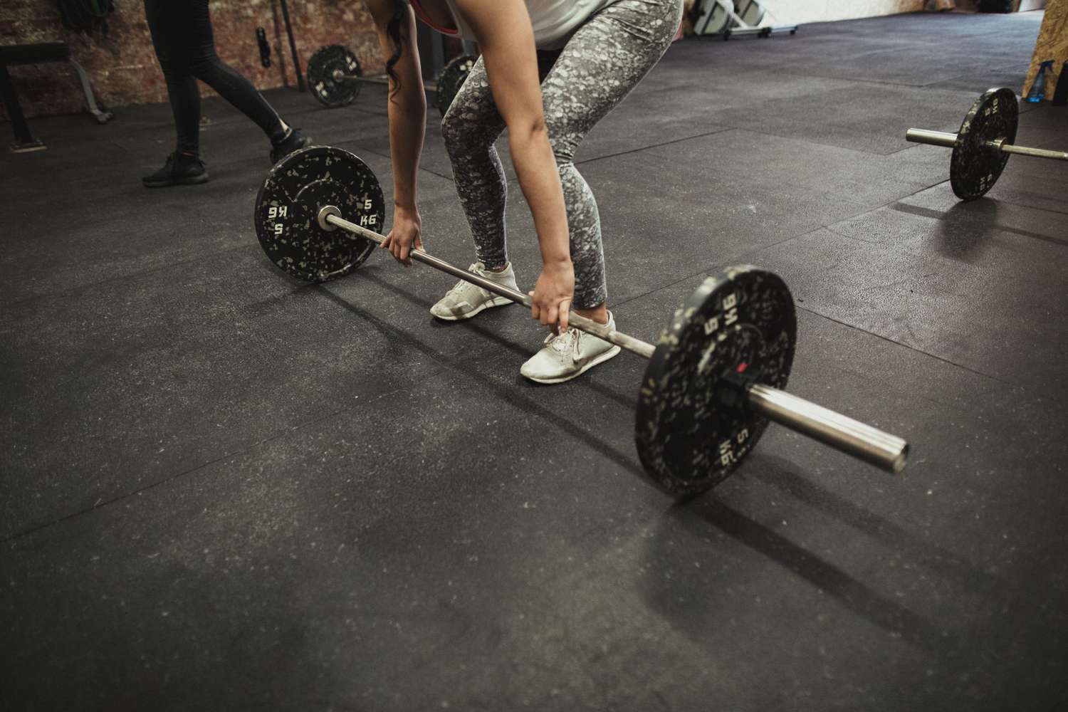 Woman Performing a Deadlift working leg, but, and back muscles