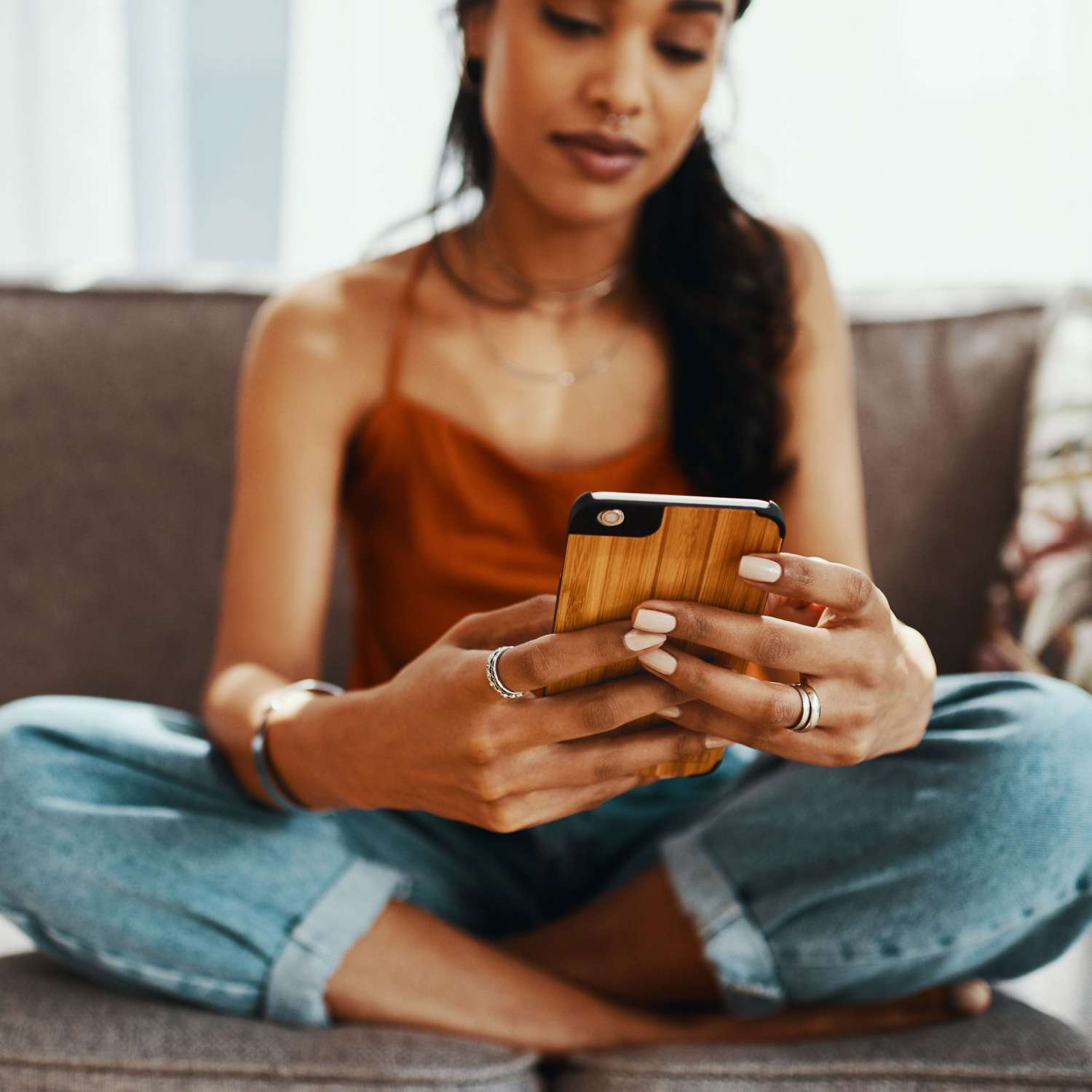 Woman_Sitting_On_Couch_Looking_At_Phone