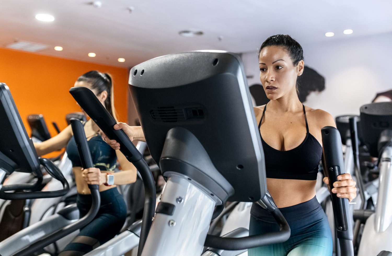 woman doing elliptical hiit workout at a gym