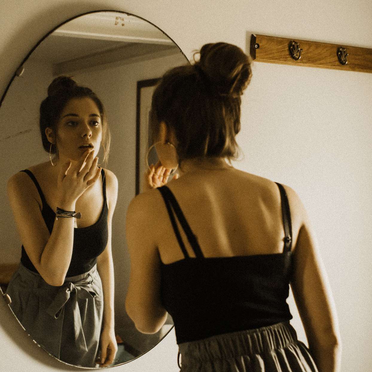 Woman looking at blemish in a mirror