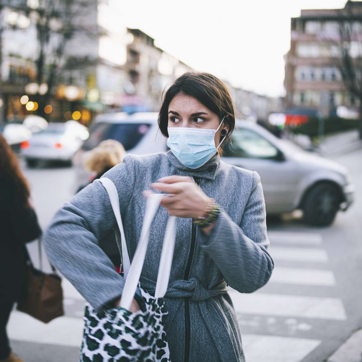 Young Woman Walking On The Street With Protective Face Mask.