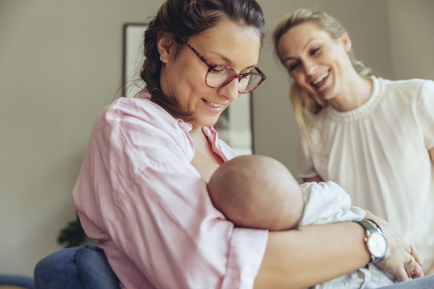 lactation consultant supporting a breastfeeding mother with her newborn baby