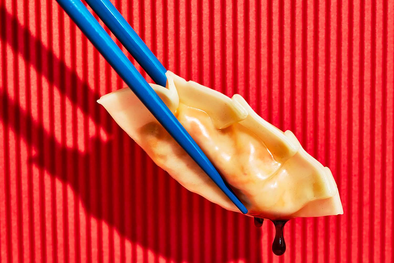 A dumpling being held by chopsticks