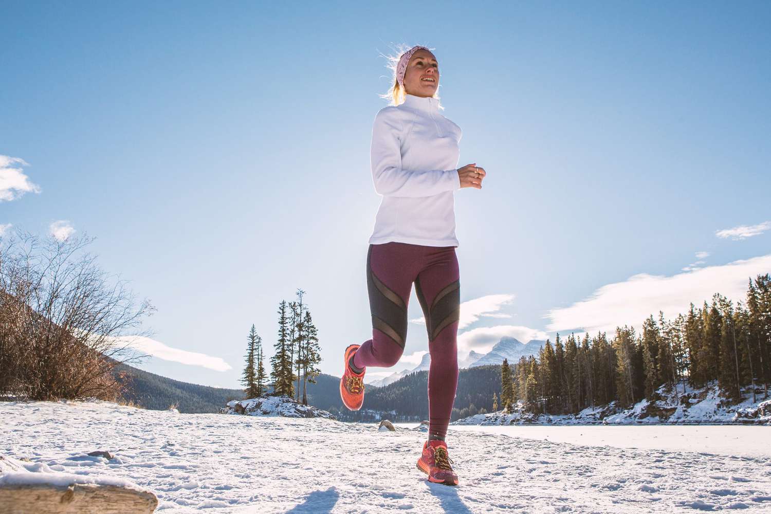 Woman exercising for cross-country running in winter jogging over snow