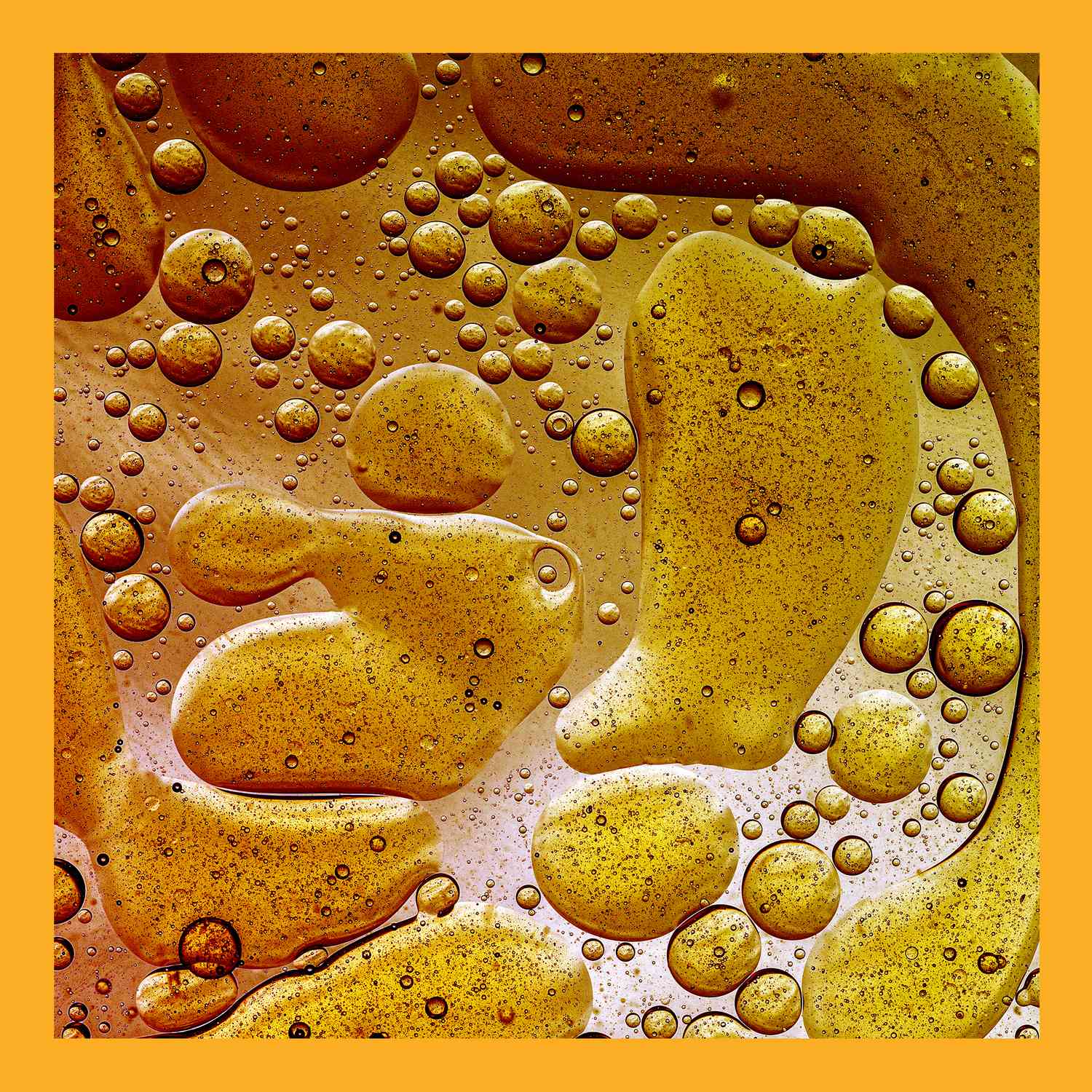 How Much Fat Should You Really Eat Every Day? , Full frame of abstract shapes and textures formed of bubbles and drops oil stains on a gold colored liquid background.