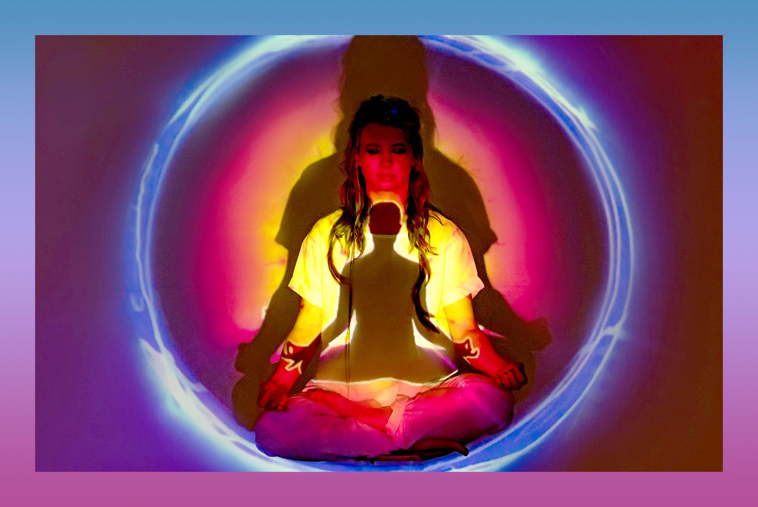woman sitting lotus pose meditating inside circle of light with aura colored lights
