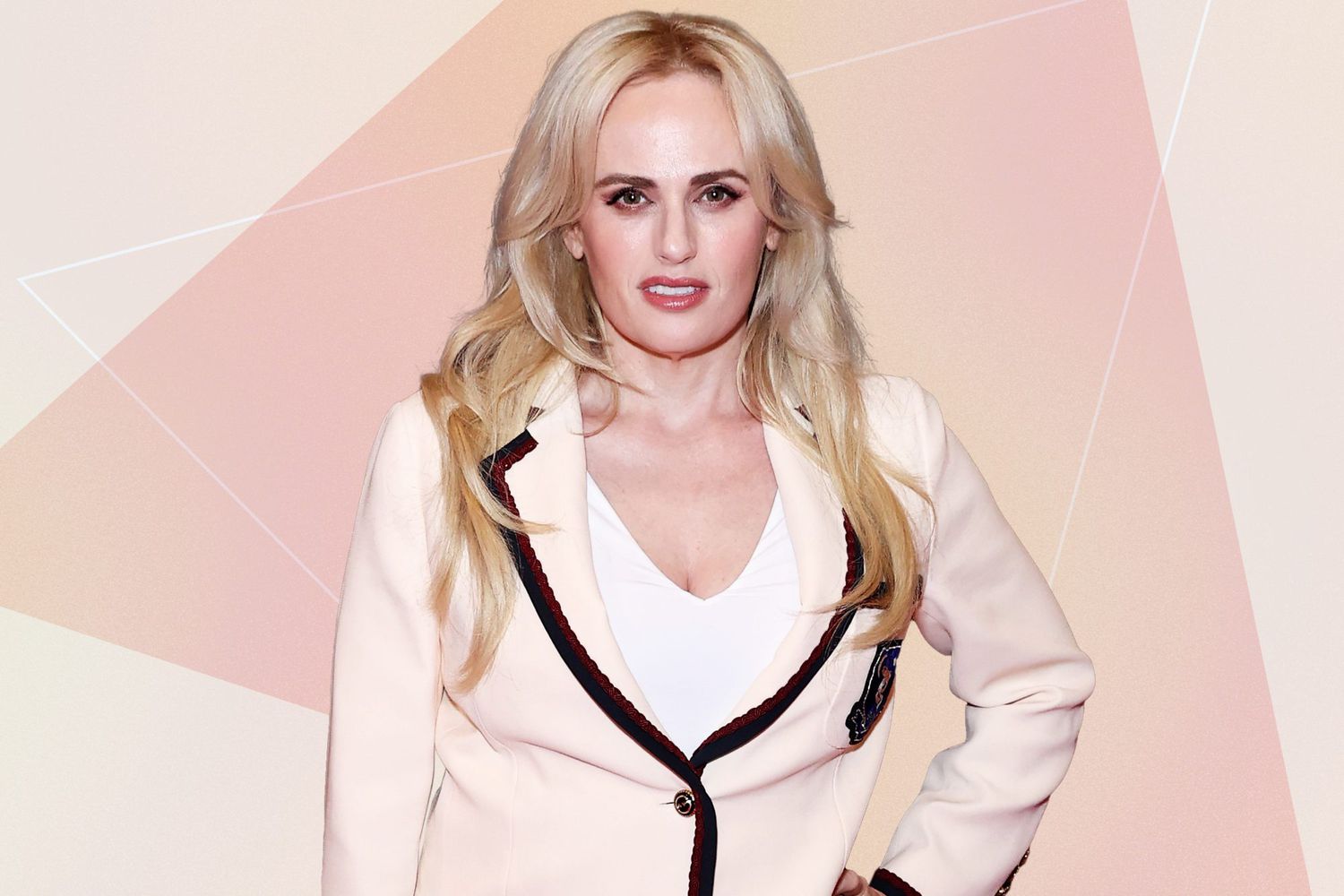 Rebel wilson wearing a pink suit against a neutral background