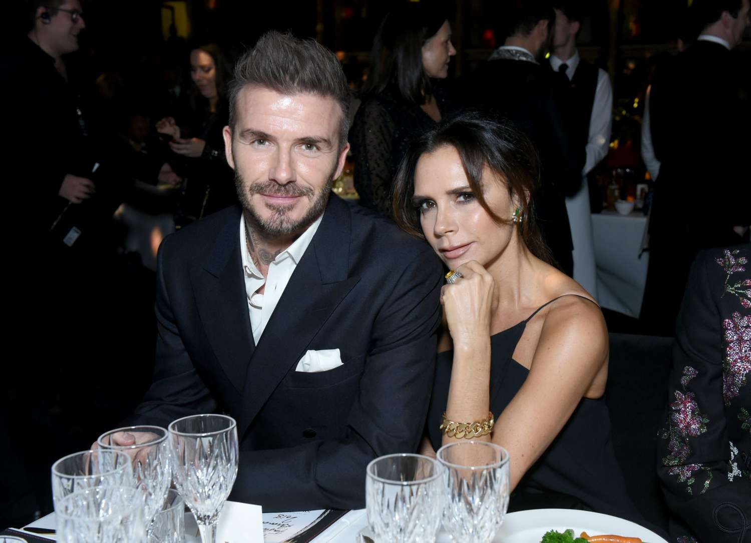 Victoria Beckham and David Beckham Sitting at Table