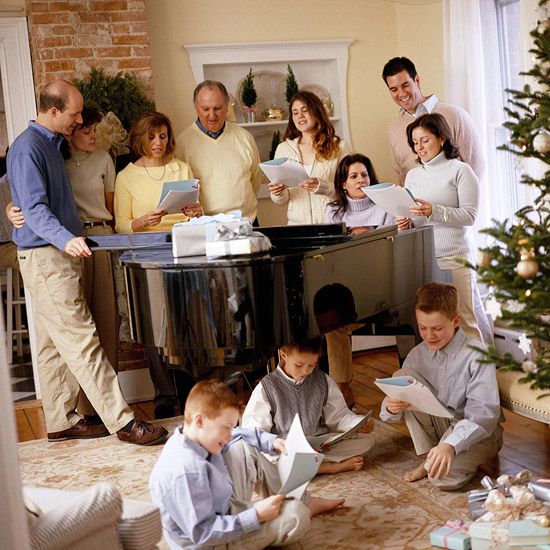 everybody around piano by Christmas trees	