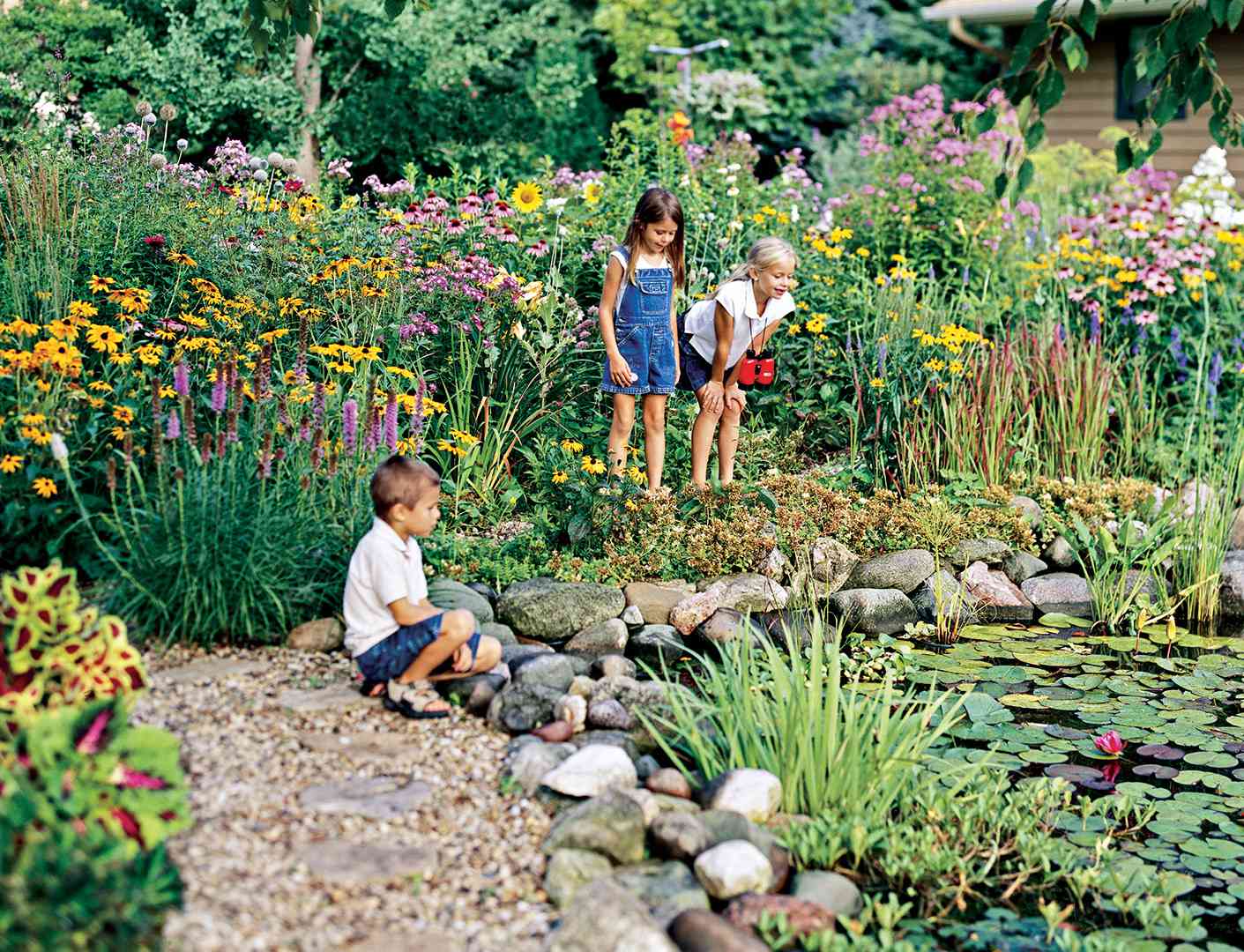 children next to pond with lily pads