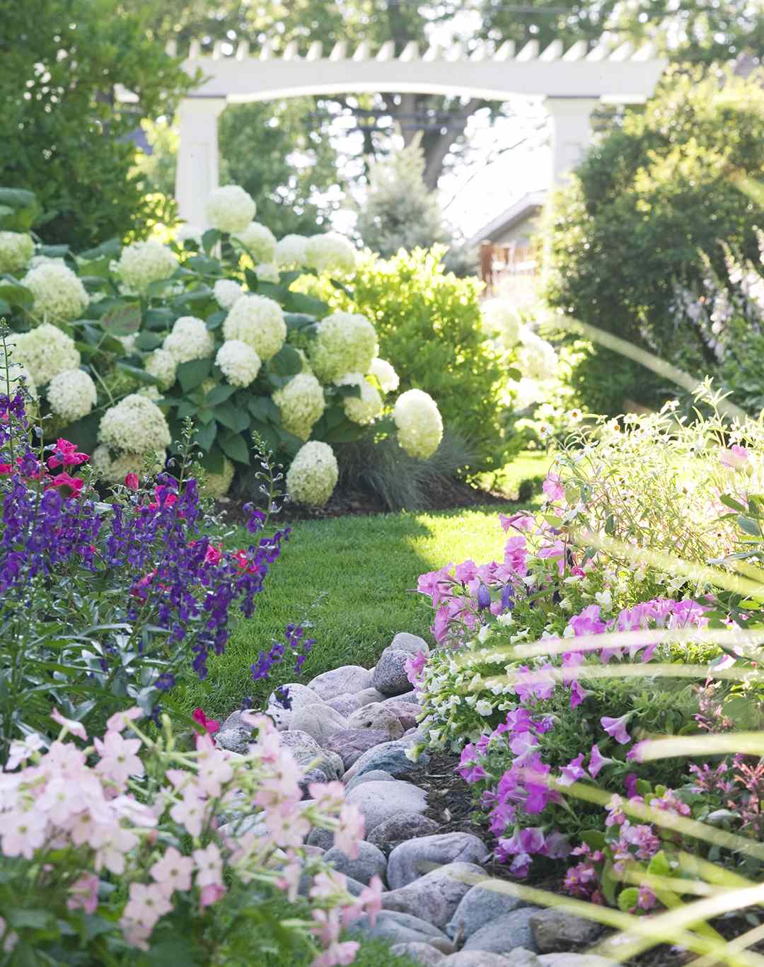 pergola in back yard with flower garden