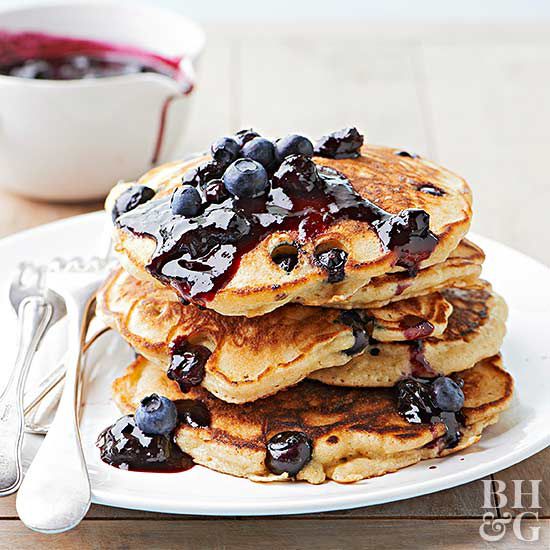 stack of lemon-ricotta pancakes topped with blueberry sauce