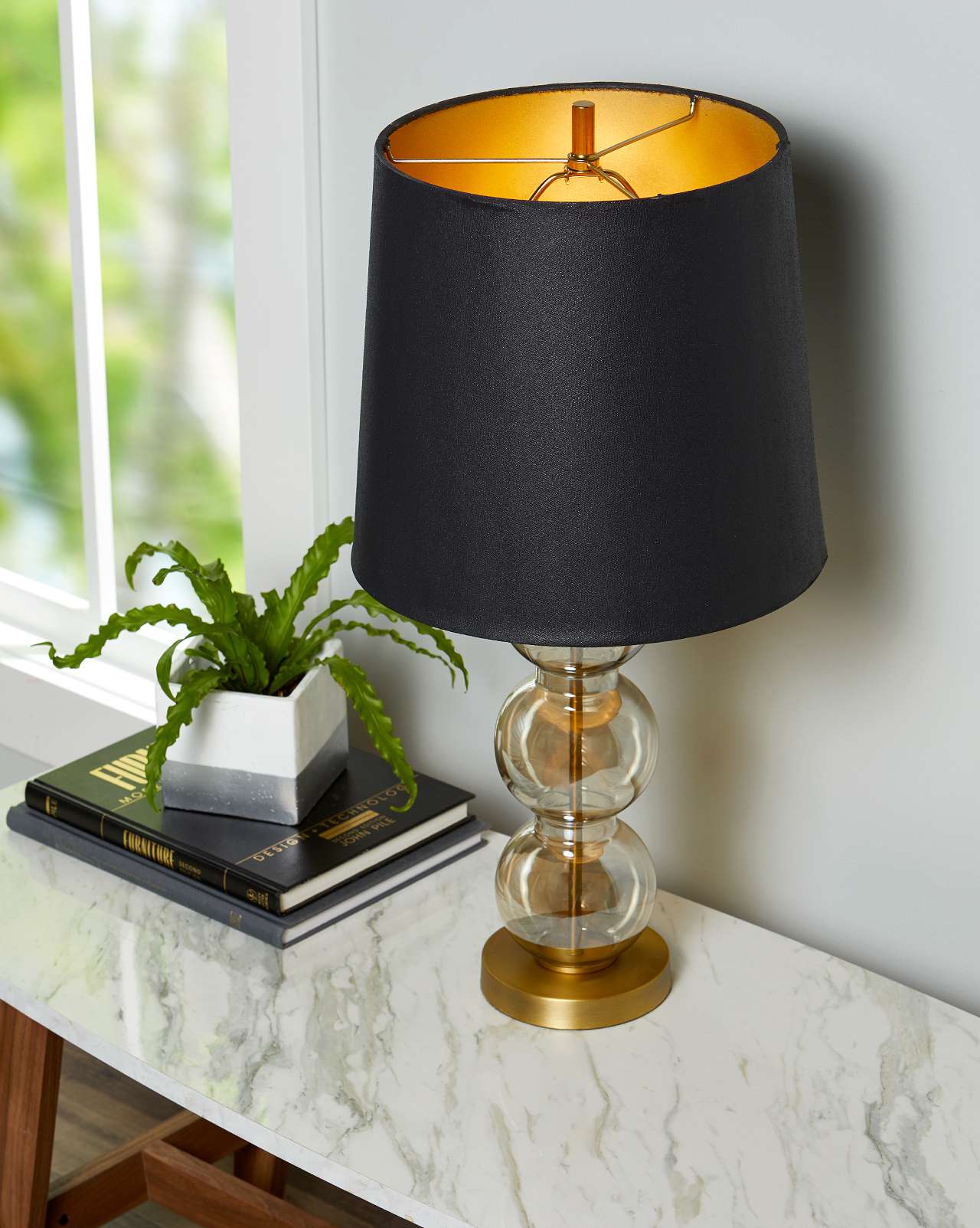 glass lamp with black lampshade on marble table