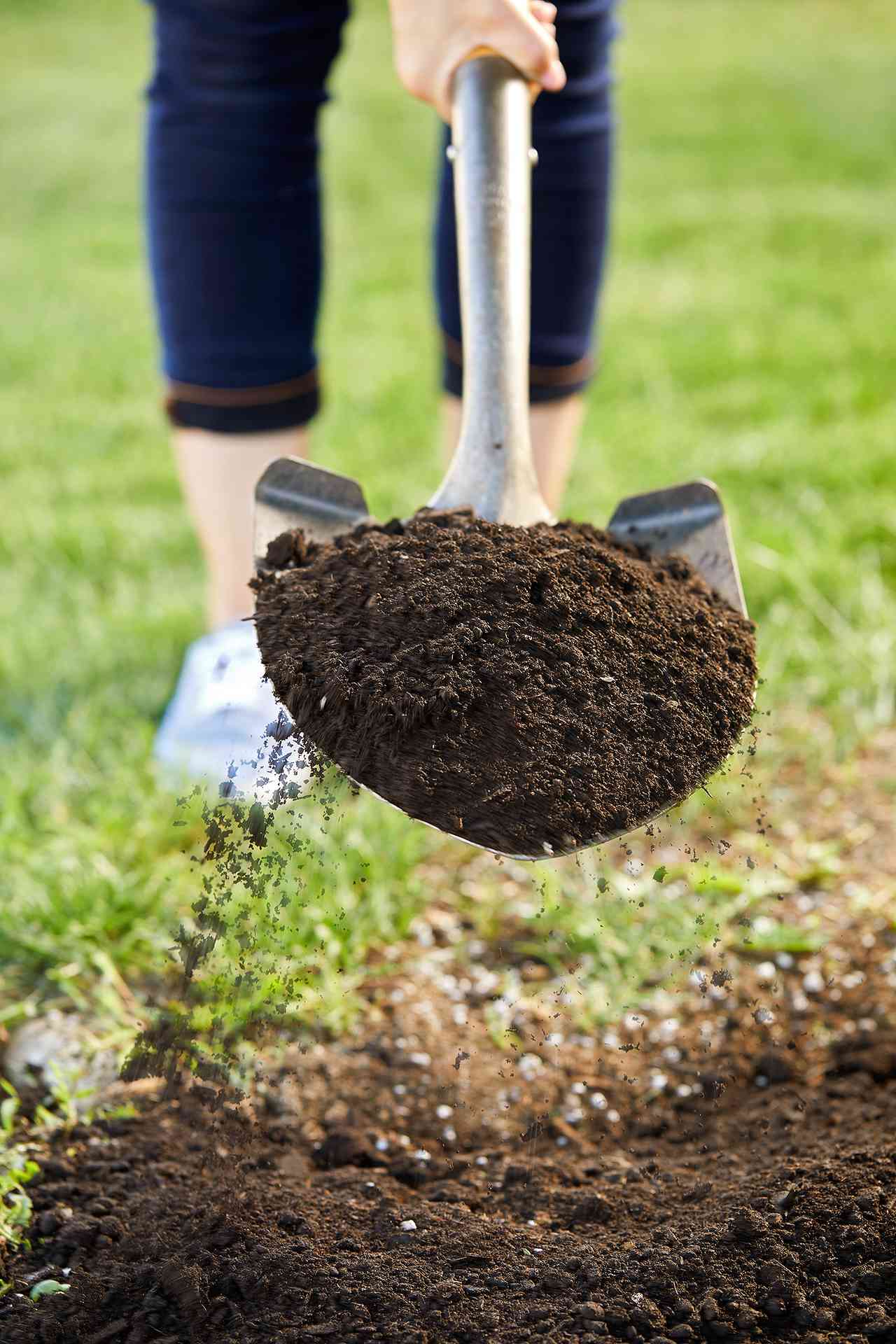 woman scooping soil with shovel