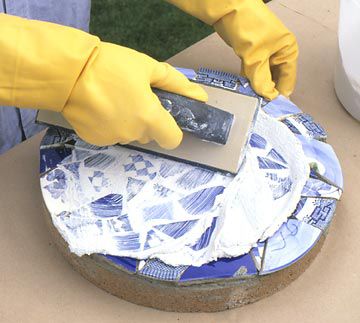 Mosaic Stepping Stone: pressing grout between mosaic tile pieces