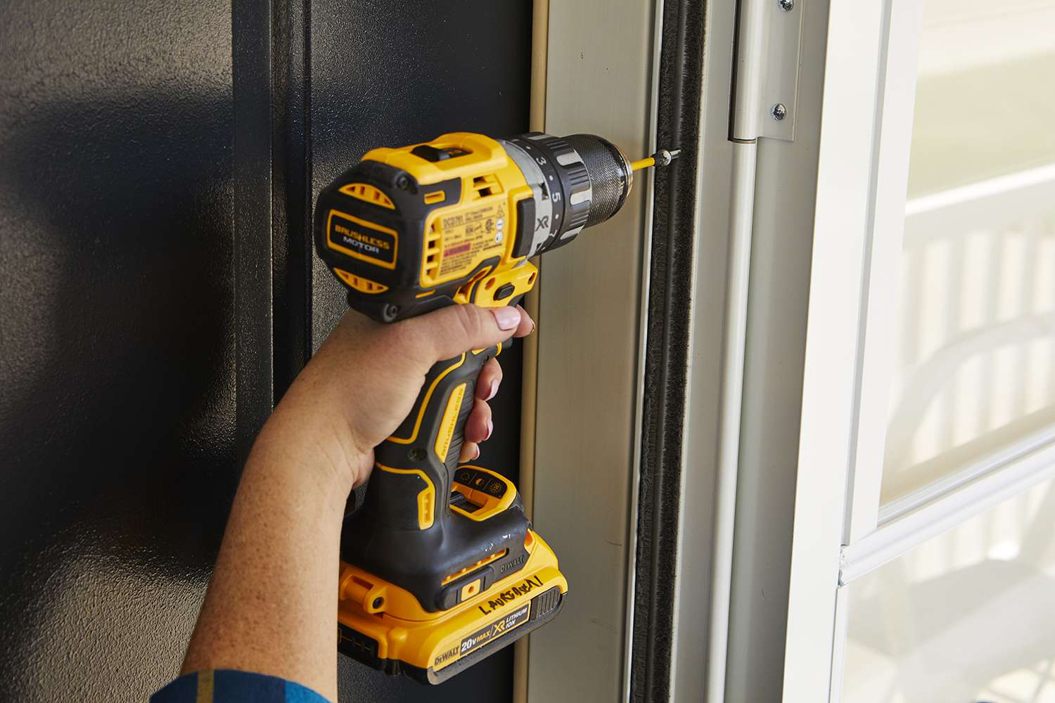 using screwdriver to tighten screw in doorframe
