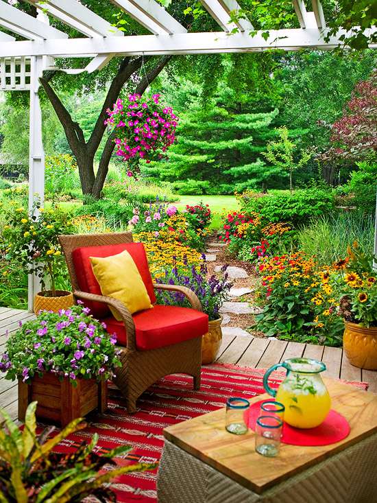 Cozy patio with outdoor furniture, flowers, drinks, and an outdoor rug	