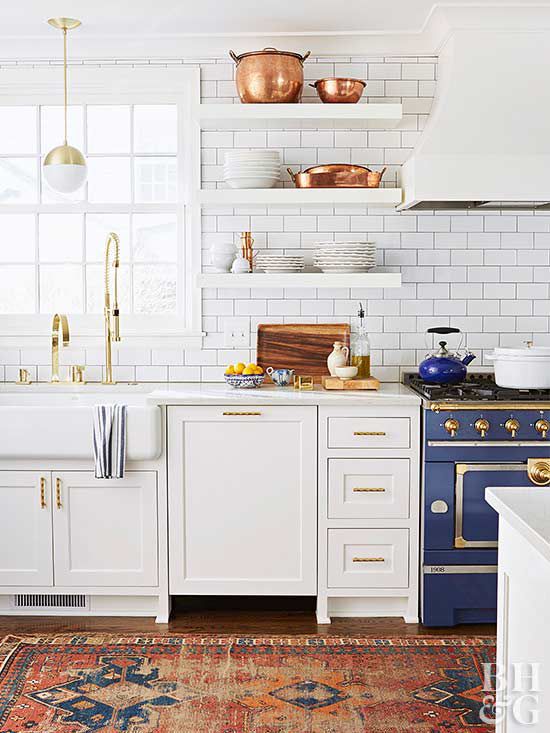 white kitchen with floating shelves and copper pots