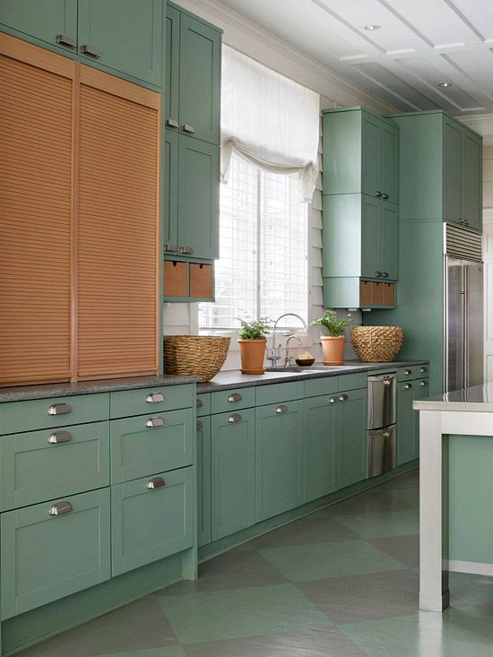 Blonde louvered panels in green cabinets