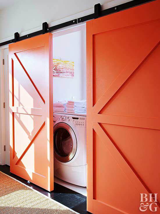 laundry room with bright orange barn doors