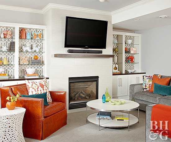 grey and orange living room with large TV mounted on wall