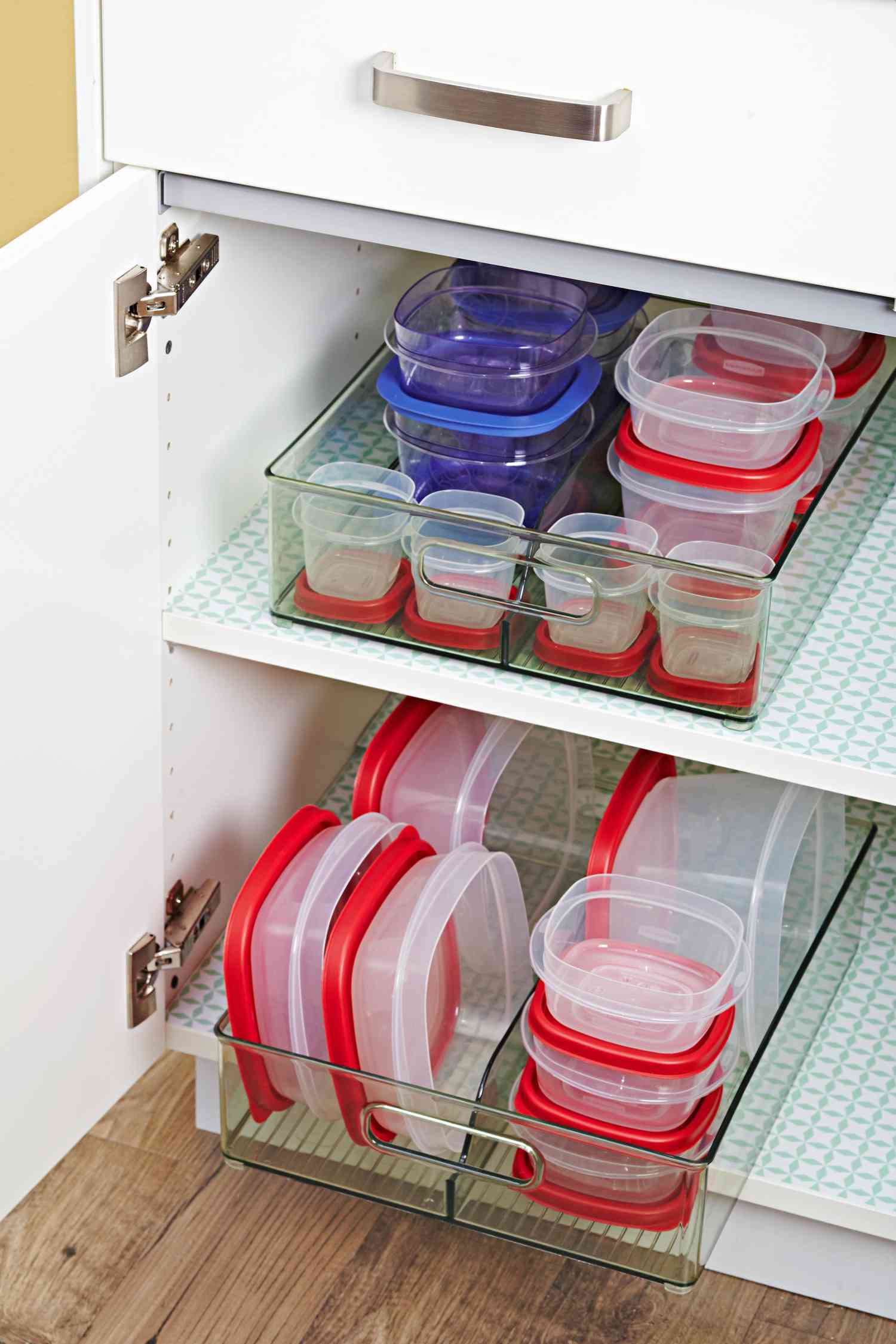 cupboard of food storage containers organized in plastic bins