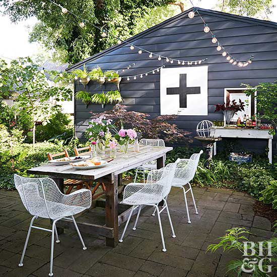backyard wood dining table with white metal chairs