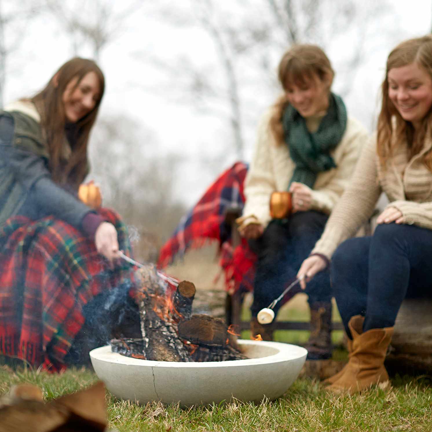 women roasting smores around diy fire bowl