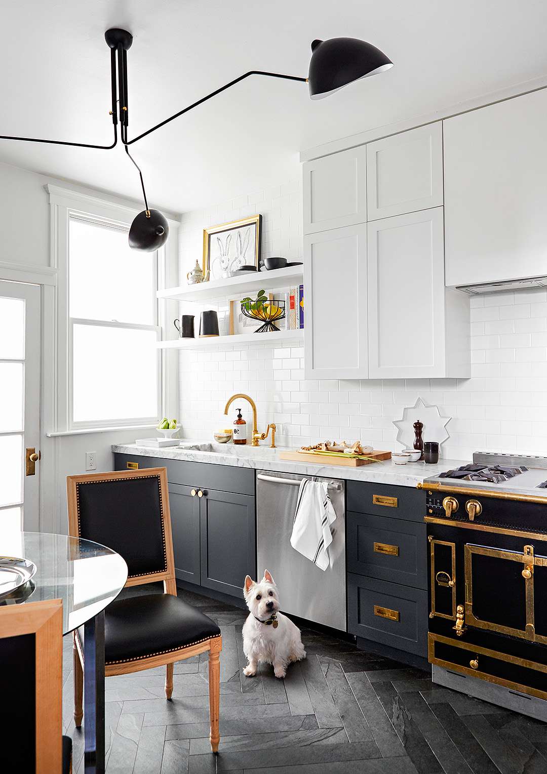 modern kitchen with dark cabinets below and white cabinets above, black and gold oven range