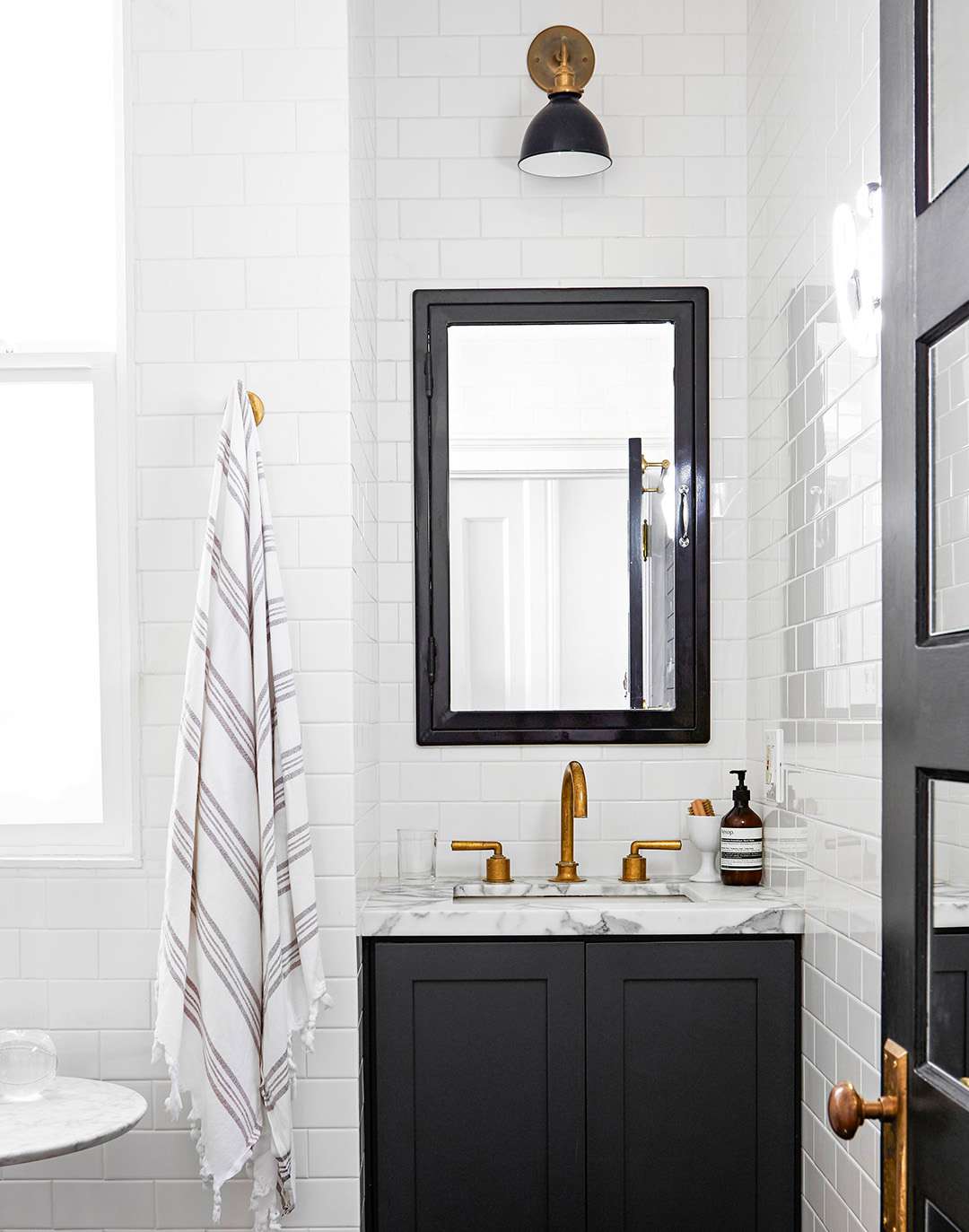 small modern bathroom with white subway tiles and black vanity