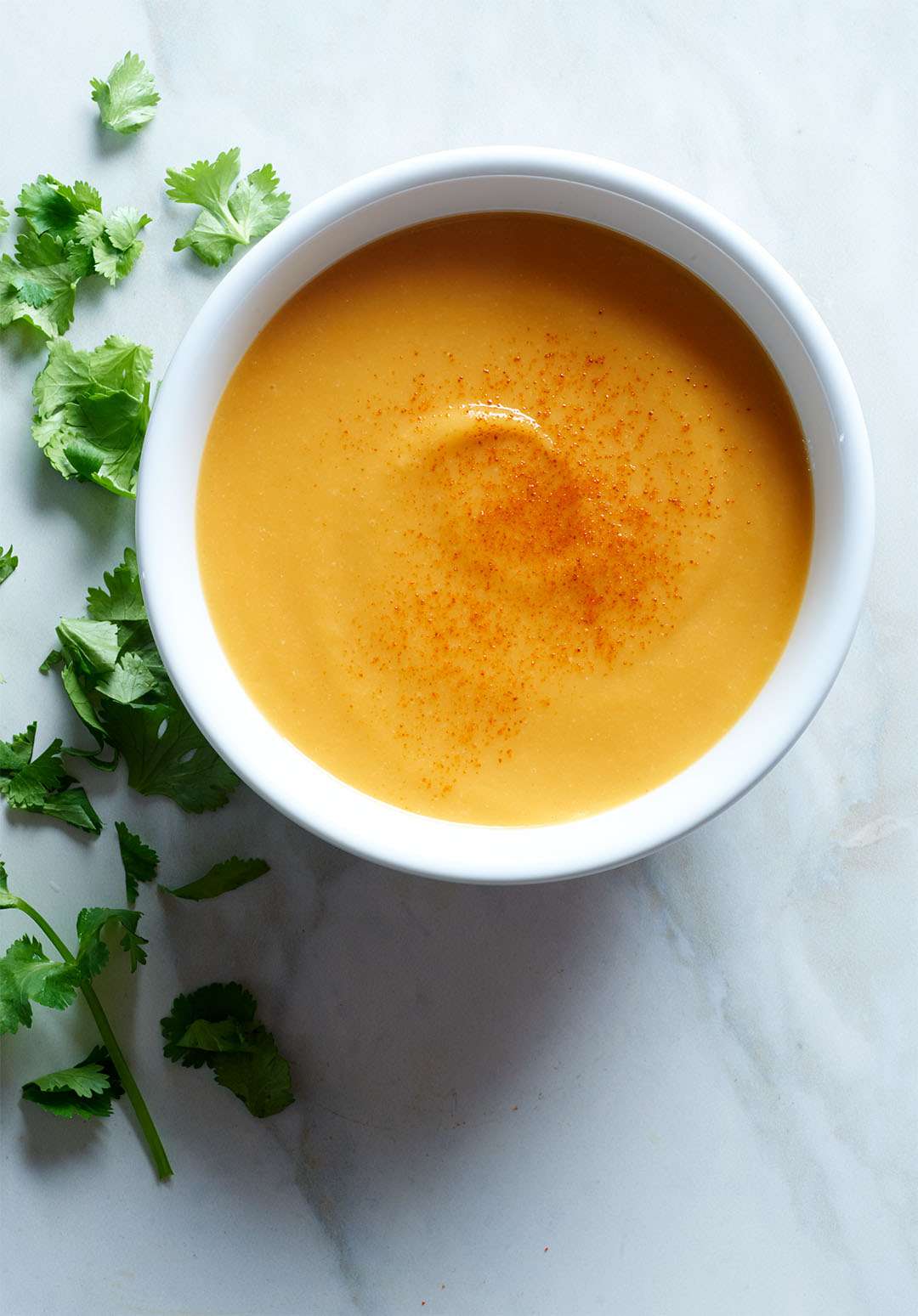 Pressure Cooker Cauliflower and Sweet Potato Soup in white bowl with parsley