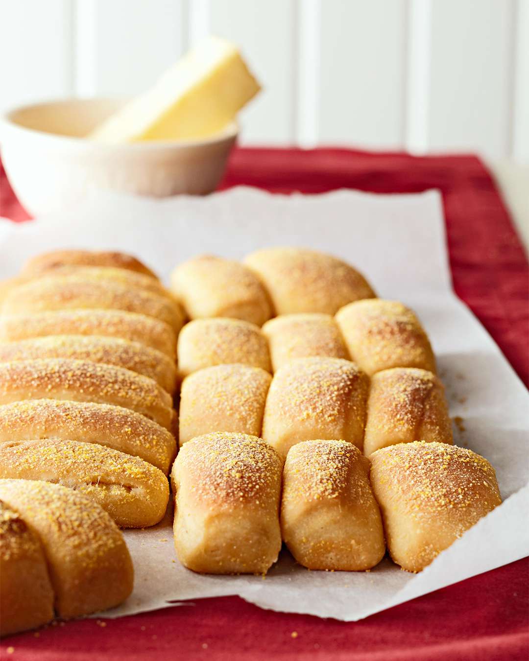 Pull-Apart Cornmeal Dinner Rolls on parchment paper with butter