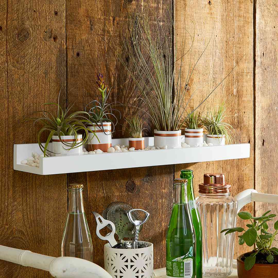 white floating shelf with pvc pipe planters