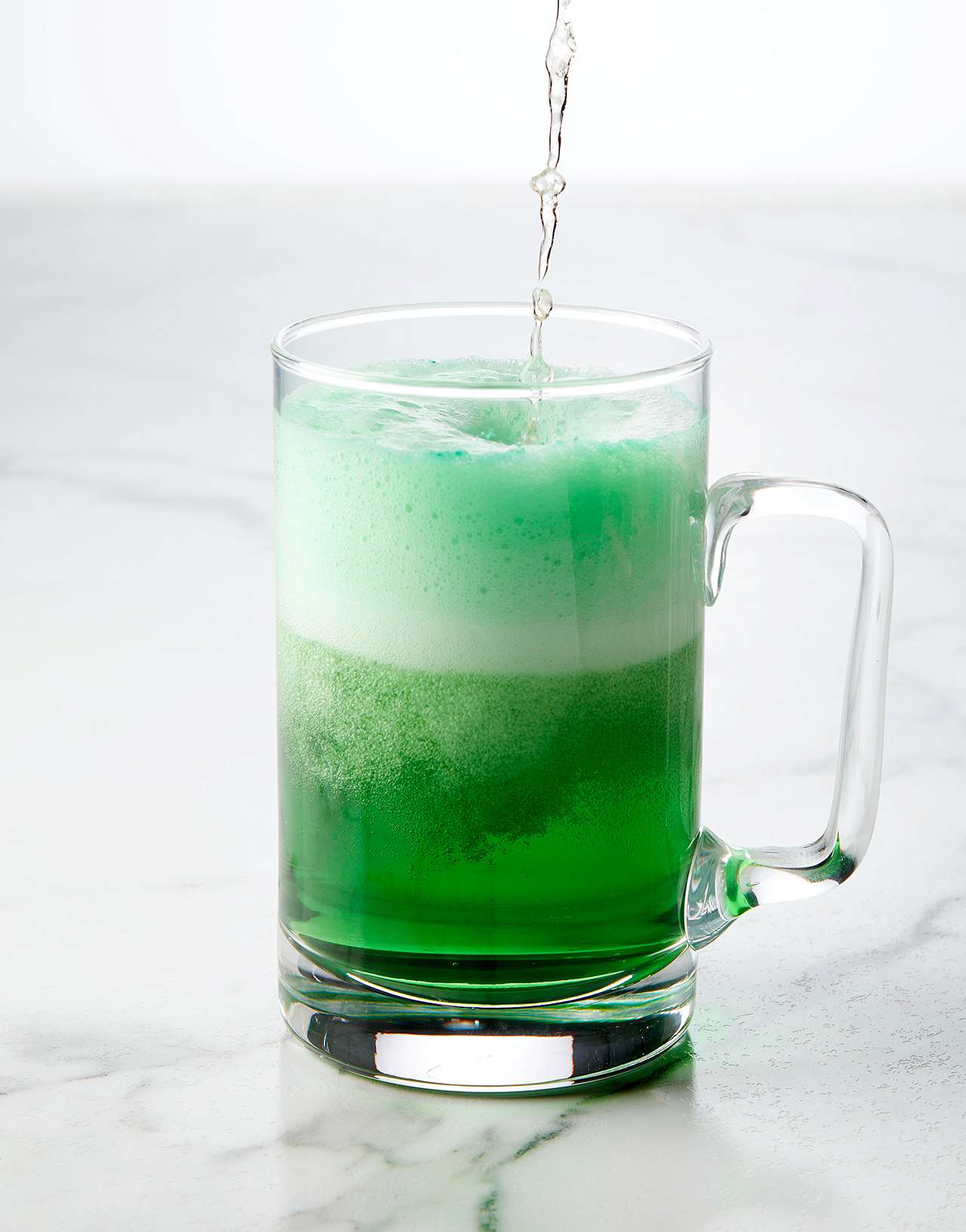 pouring beer into glass with food coloring