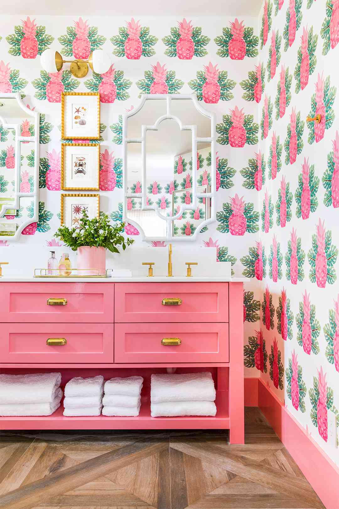 bathroom with pink pineapple wallpaper and pink his and her sinks
